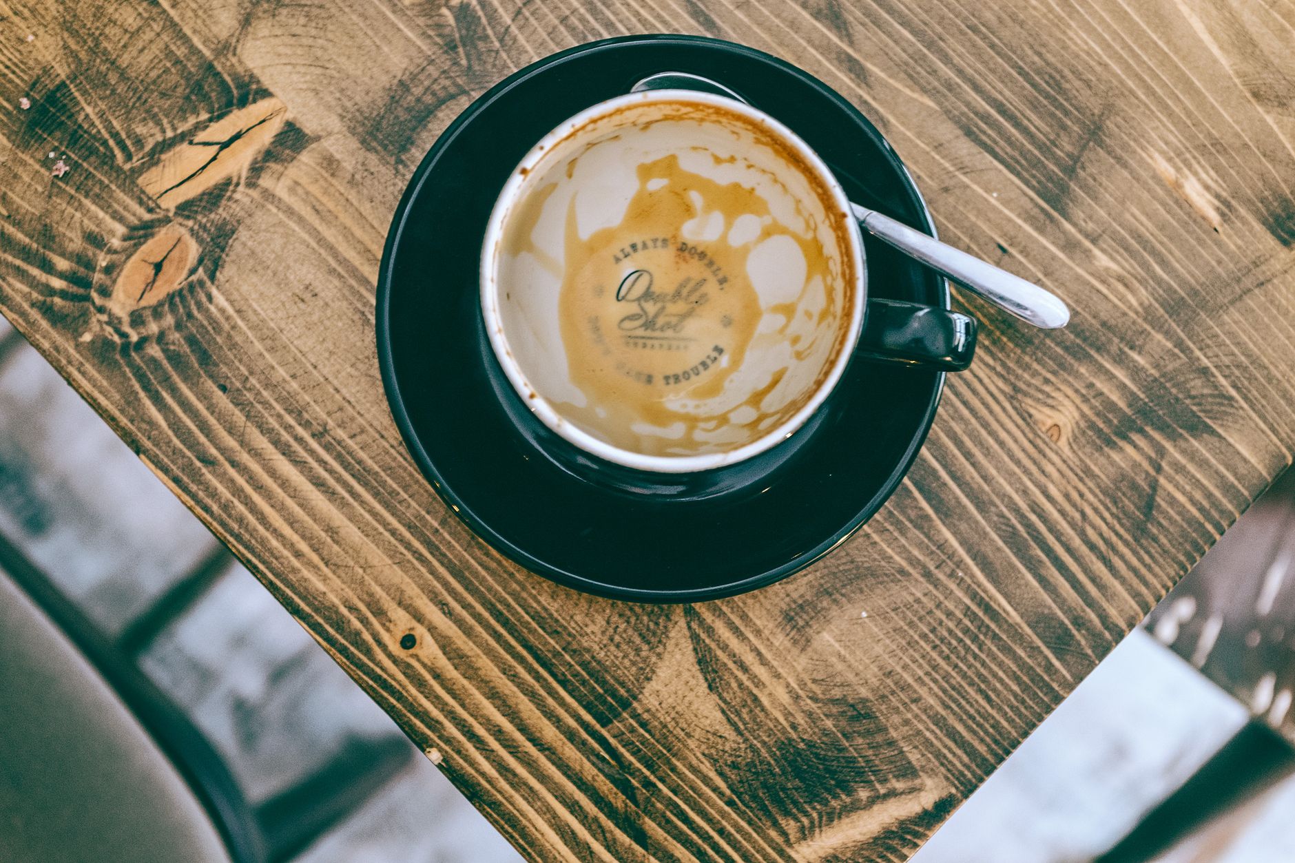 倫理 経営者の集いを思わせる明るいカフェの窓辺のテーブルとコーヒーカップ