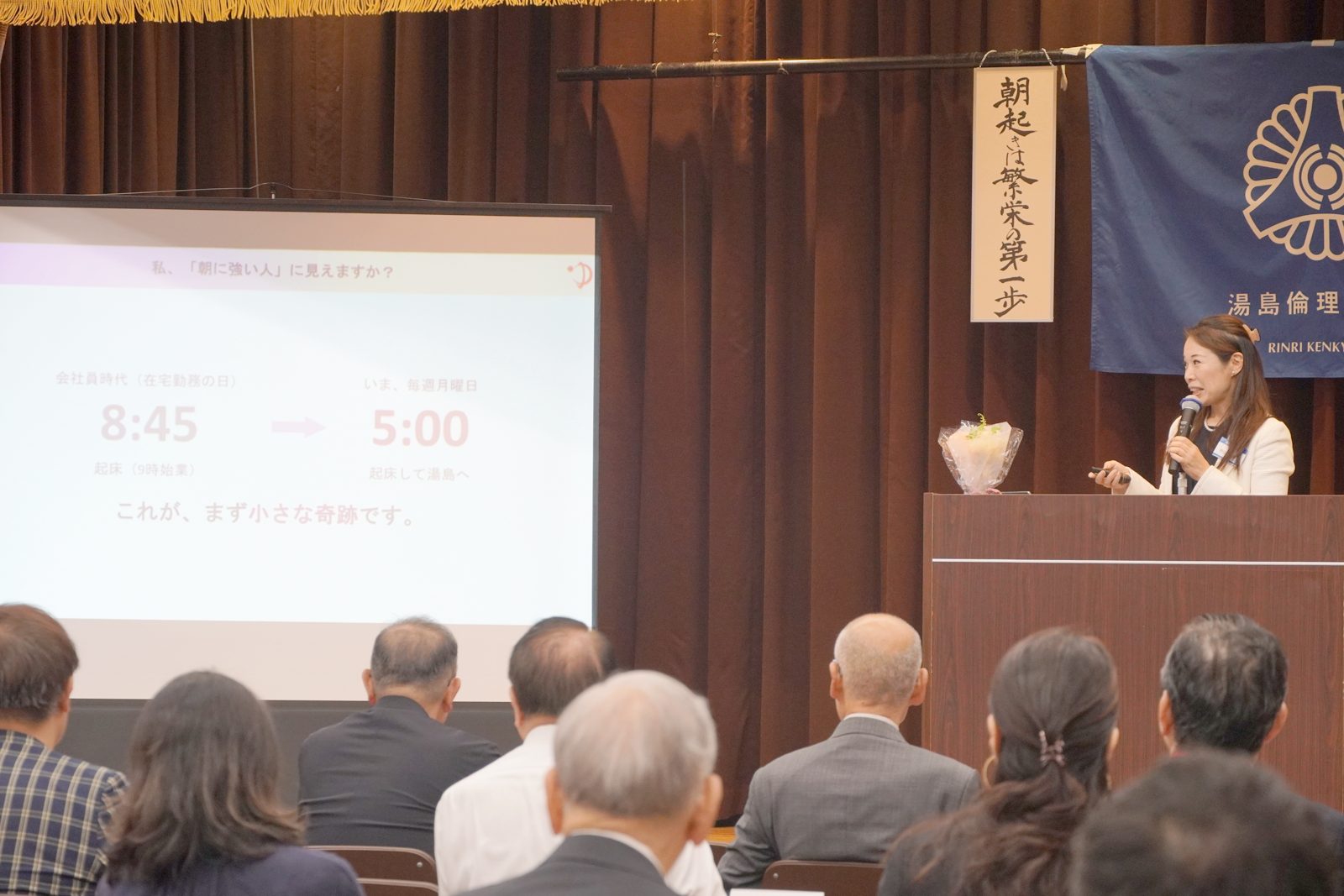 「8:45→5:00」のスライドとともに、朝起きの一年を語る