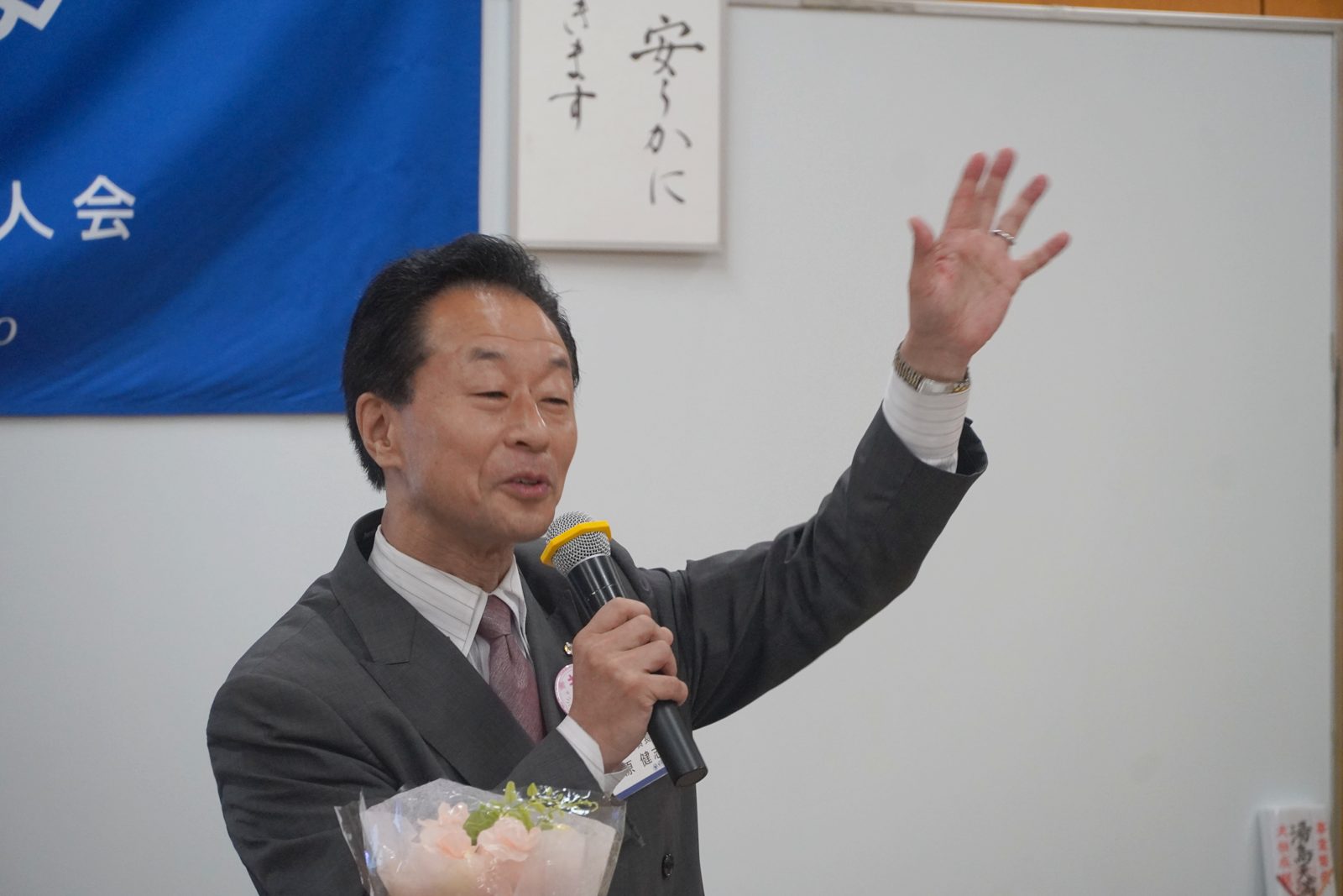 手を高く挙げ、会場に呼びかける小原健志氏