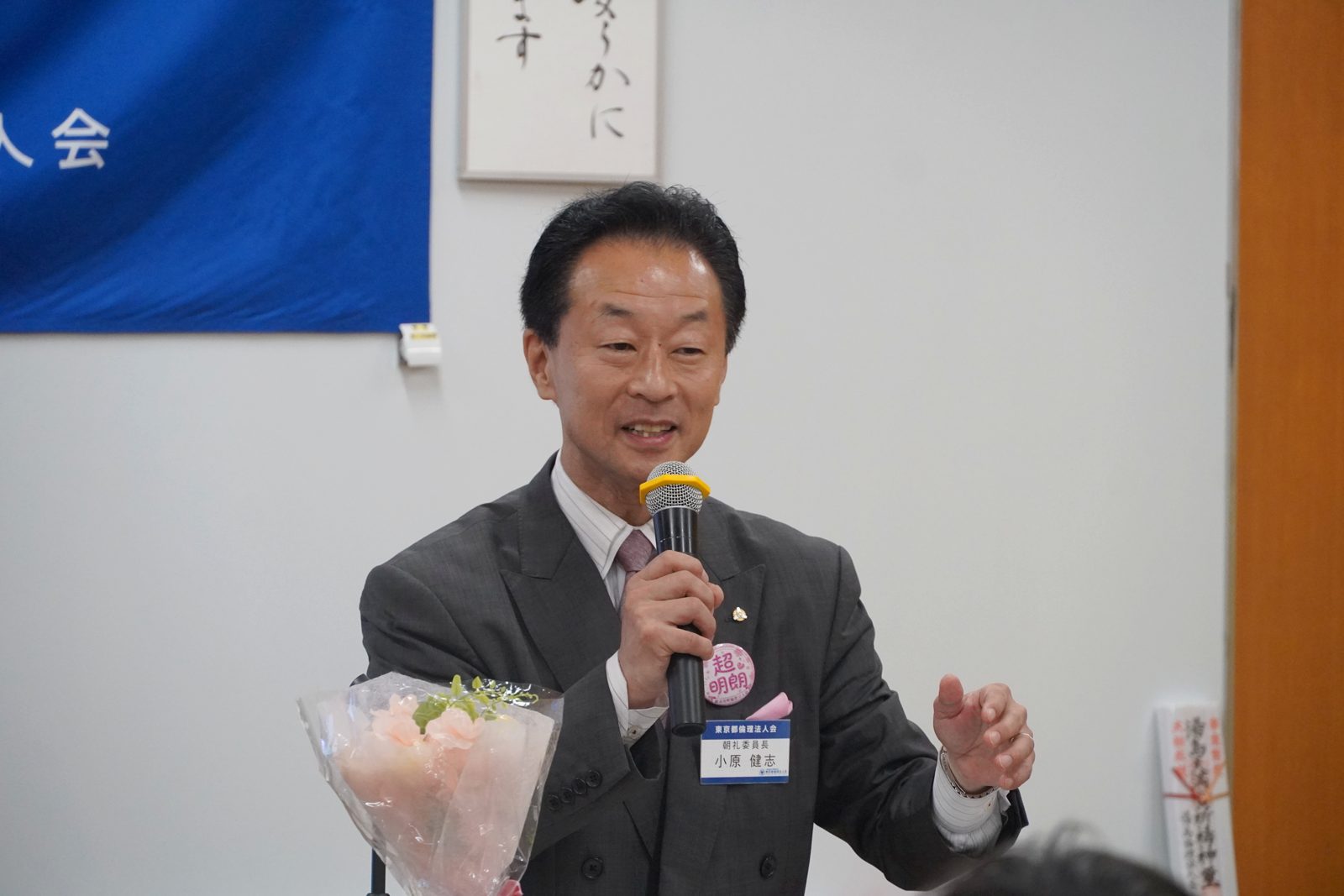 胸に「超明朗」のバッジを着けて語る小原健志氏