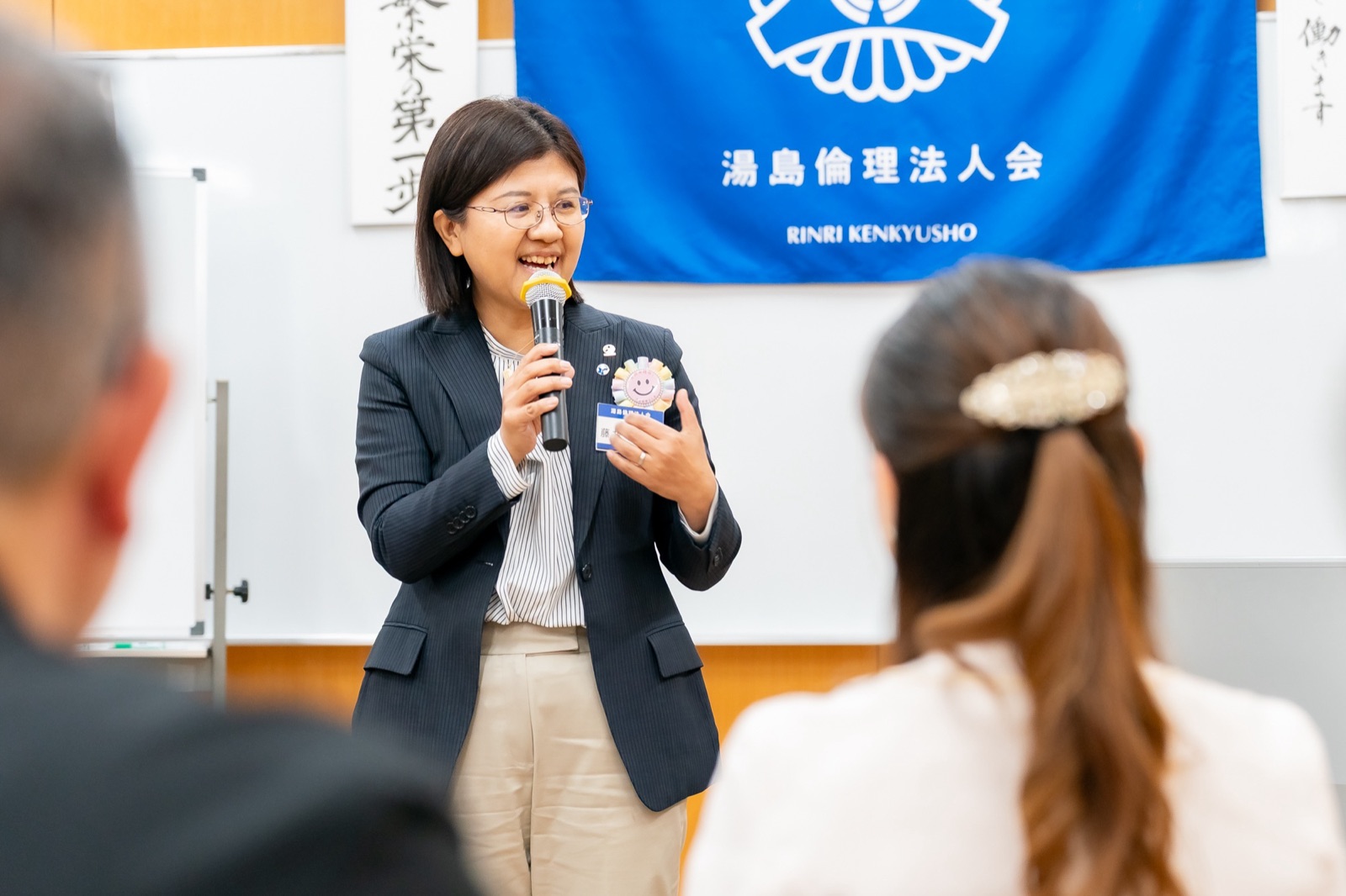 参加者に向けて笑顔で話す湯島の講話風景